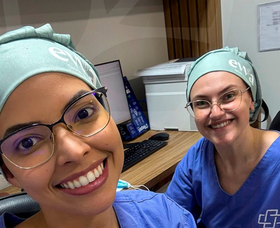 Dra. Talita Martinelli e Dra. Isabela Guimarães de touca cirúrgica com o logo do EVVA, sorrindo
